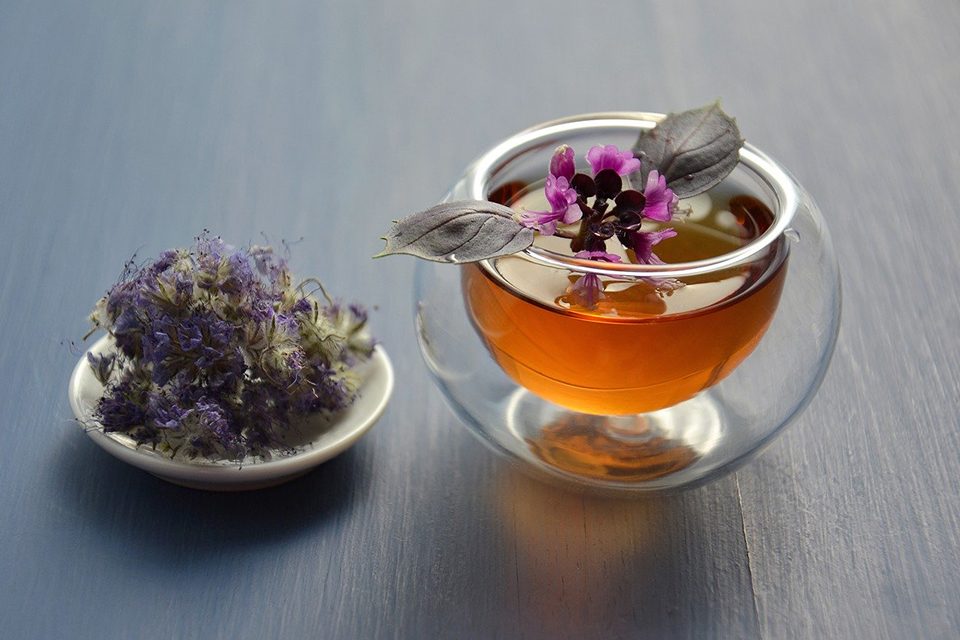 tasse de thé avec fleurs dans soucoupe