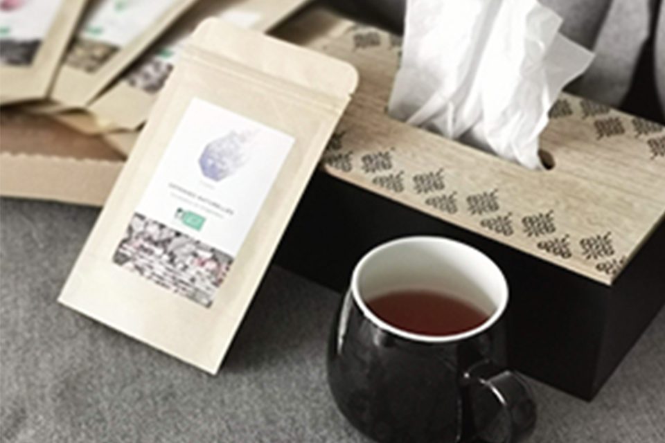tasse de thé, boite de mouchoirs et sachet thé sur canapé gris tasse de thé, boite de mouchoirs et sachet thé sur canapé gris