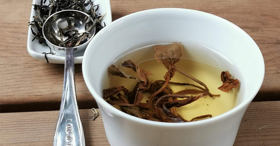 thé jaune dans coupelle et feuilles de thé jaune avec cuillère à thé colors of tea